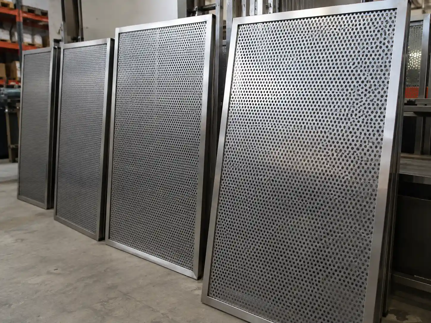 Framed perforated metal screen panels prepared for architectural and industrial installation